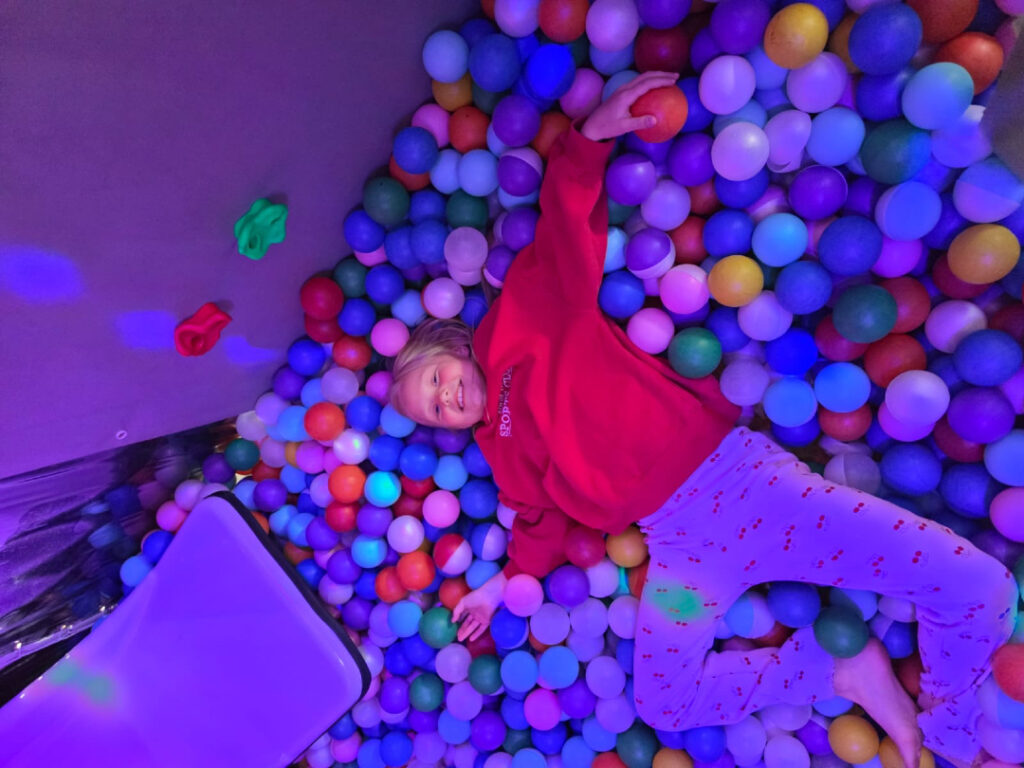A child enjoying the colourful ball pit inside Essex Soft Play Bus
