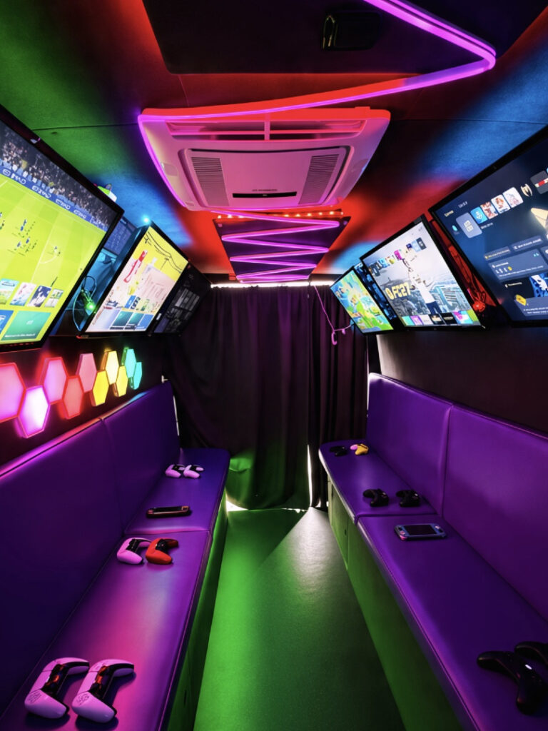 Gaming screens, controllers and colourful lighting inside Essex Gaming Bus